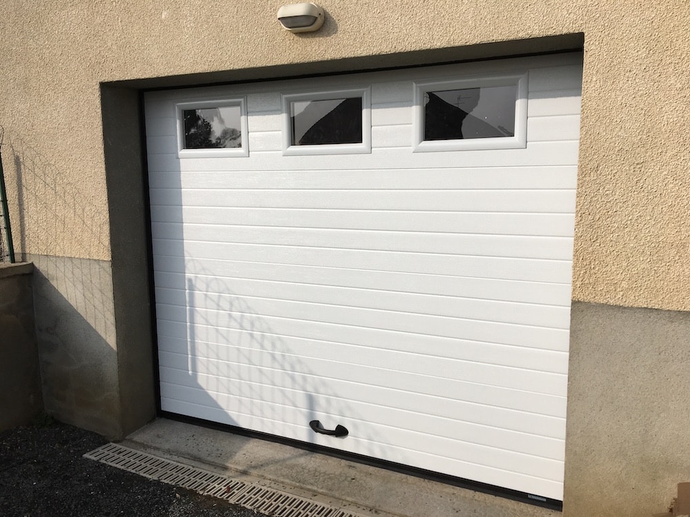 Porte de garage rainurée blanche avec hublots